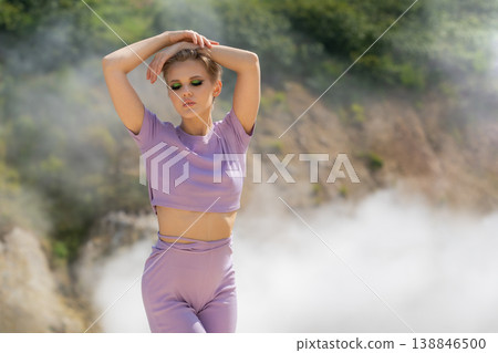 Elegant woman with short hair and green eyeshadow posing in a misty natural setting Elegant woman with short hair and green eyeshadow posing in a misty natural setting 138846500