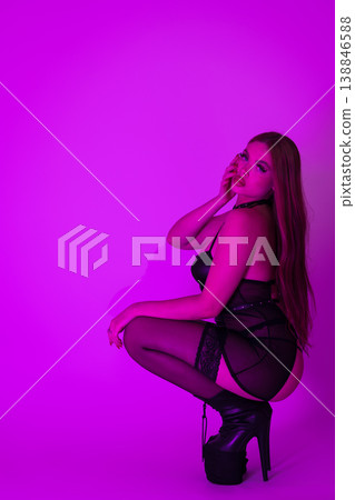 Side view sexy woman femme fatale wearing lingerie, stripper heels squatting and looking at camera Side view sexy woman femme fatale wearing lingerie, stripper heels squatting and looking at camera 138846588