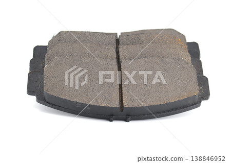 Close-up of a worn automotive brake pad with a central groove on a white background 138846952