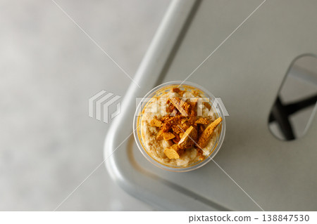 Cup of chilled milk dirty coffee topped with sweet honeycomb. 138847530