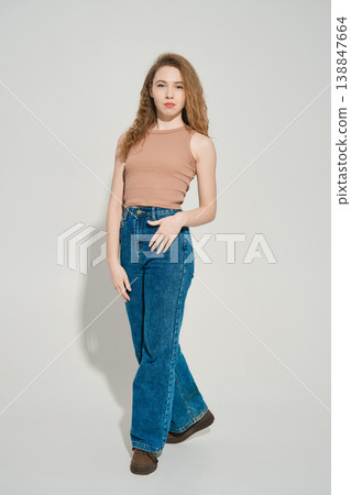 Woman poses in casual outfit with light background in modern indoor space during day 138847664