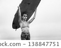 Strong woman with dramatic makeup holding surfboard over her head in black and white 138847751