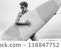 Artistic black and white portrait of strong woman with short hair holding surfboard 138847752