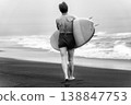 Black and white rear view of female surfer carrying surfboard and walking on beach 138847753