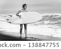 Athletic woman with surfboard standing on beach. Black and white photo 138847755