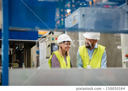 Industrial team evaluate the production process in high tech manufacturing plant. Industrial team evaluate the production process in high tech manufacturing plant. 138850164