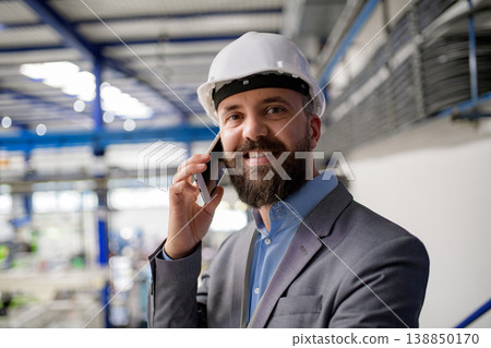 A portrait of project manager or engineer factory, making phone call. A portrait of project manager or engineer factory, making phone call. 138850170