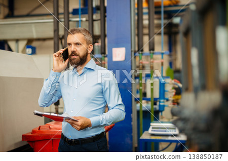 A portrait of project manager or engineer factory, making phone call. A portrait of project manager or engineer factory, making phone call. 138850187