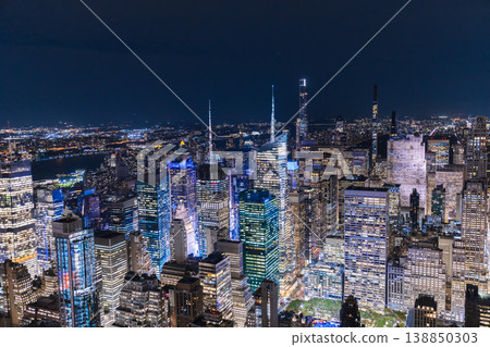 Night aerial view of Midtown Manhattan skyline with illuminated skyscrapers and dense urban city lights in New York City USA Night aerial view of Midtown Manhattan skyline with illuminated skyscrapers and dense urban city lights in New York City USA 138850303