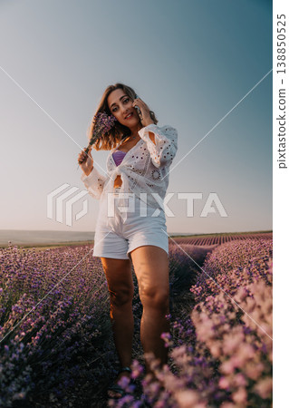 Lavender woman smartphone standing in a blooming purple field at sunset enjoying nature while talking on mobile phone 138850525