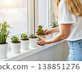 A woman carefully tending to her indoor plants. 138851276