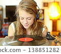 A woman relaxing while listening to her favorite records. 138851282