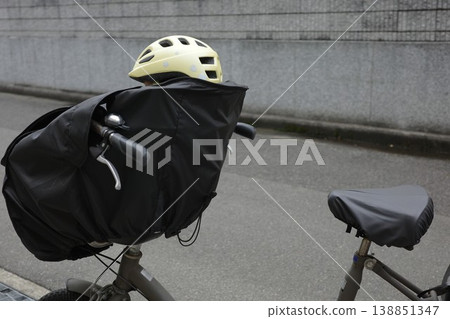 A bicycle used for transporting children, with a child wearing a yellow helmet on board. A bicycle used for transporting children, with a child wearing a yellow helmet on board. 138851347