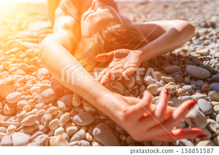Woman beach pebbles woman lying on stony shore in bright sunlight enjoying summer vacation 138851587