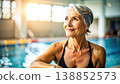 Happy senior woman laughing while doing water aerobics in swimming pool. Healthy elderly lifestyle, fitness for seniors, and active retirement concept with water splashes and bright sunlight 138852573