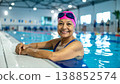Happy senior woman laughing while doing water aerobics in swimming pool. Healthy elderly lifestyle, fitness for seniors, and active retirement concept with water splashes and bright sunlight 138852574