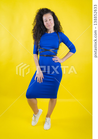Young woman showcasing modern style in blue dress and black harness 138852633