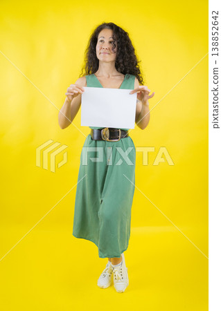 Pensive woman presenting blank sign looking thoughtfully Pensive woman presenting blank sign looking thoughtfully 138852642