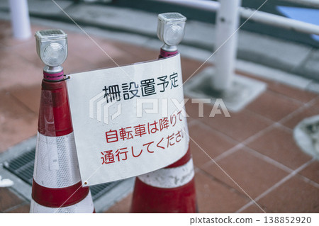 Construction notice and traffic cones for planned fence installation. 138852920