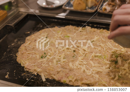 A scene of cooking cheese monjayaki on a griddle. 138853007