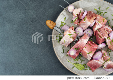 Raw pork skewers with onion and herbs on plate Raw pork skewers with onion and herbs on plate 138853072