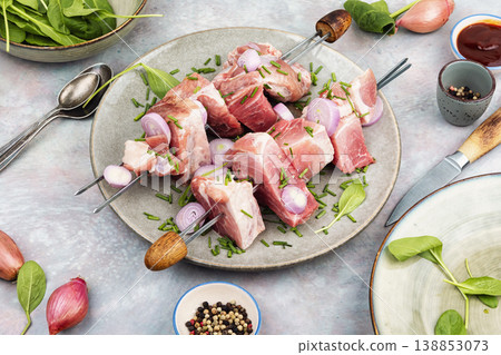 Uncooked pork kebabs with onion on skewers Uncooked pork kebabs with onion on skewers 138853073