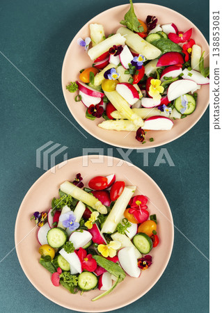Colorful Vegetable Salad with Asparagus, Radishes and Edible Flowers on a Plate 138853081