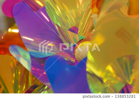 Bright iridescent holographic texture with vibrant pink, orange and yellow colors. Abstract background photography showing colorful light reflections, neon gradients and creative aesthetic ripples. 138853281