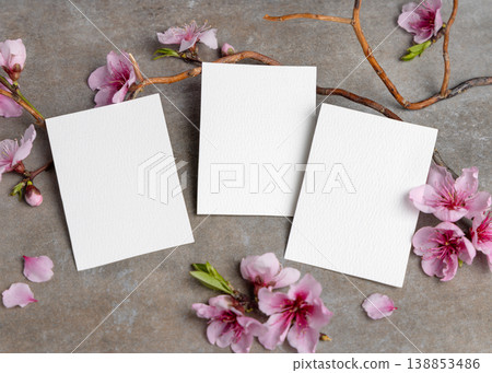 Blank cards mockup with pink cherry blossoms and twigs on grey stone. Spring wedding stationery set 138853486