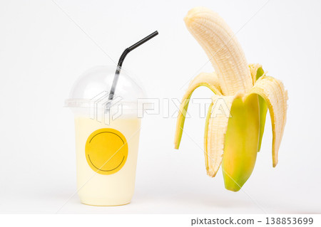 Delicious banana treat alongside creamy shake captures the essence of indulgent flavors in a playful moment at the white background. Delicious banana treat alongside creamy shake captures the essence of indulgent flavors in a playful moment at the white background. 138853699