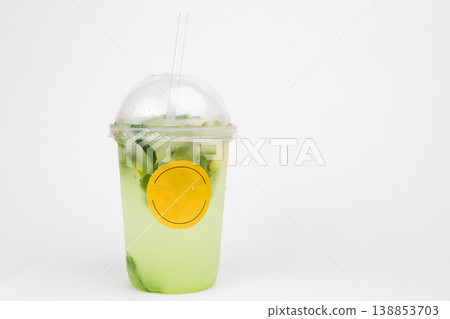 Refreshing mint lemonade served in a clear cup adorned with a cheerful yellow label, perfect for a sunny day at a bustling outdoor cafe Refreshing mint lemonade served in a clear cup adorned with a cheerful yellow label, perfect for a sunny day at a bustling outdoor cafe 138853703