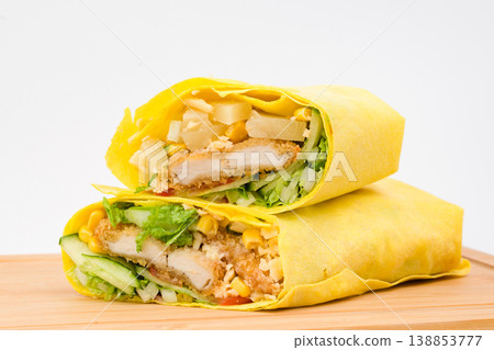 Delicious golden wrap filled with crispy chicken, fresh lettuce, and colorful veggies, showcasing a delightful culinary experience on a wooden platter Delicious golden wrap filled with crispy chicken, fresh lettuce, and colorful veggies, showcasing a delightful culinary experience on a wooden platter 138853777