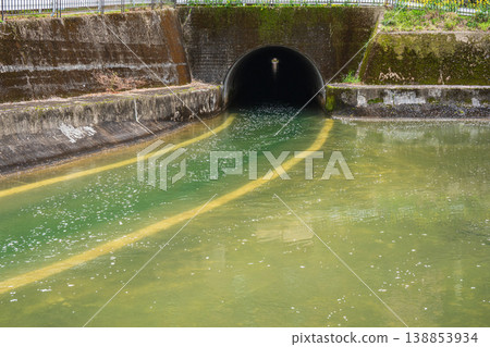 The Lake Biwa Canal, with cherry blossom petals floating on its surface, at the exit of the Moroha Tunnel, Kyoto City. The Lake Biwa Canal, with cherry blossom petals floating on its surface, at the exit of the Moroha Tunnel, Kyoto City. 138853934