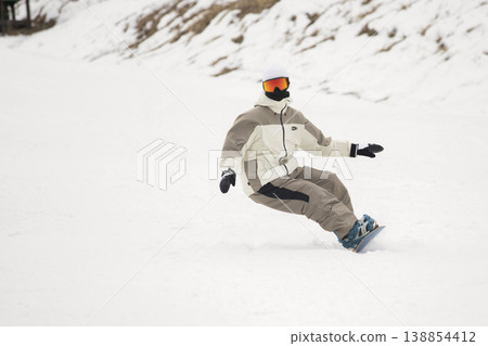 A man snowboarding down the slopes. A man snowboarding down the slopes. 138854412