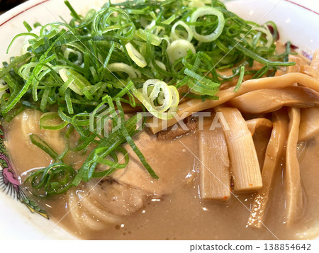 Tonkotsu Ramen - A close-up of the rich broth, green onions, and bamboo shoots. 138854642