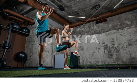 Man and woman performing high knee exercise during functional training in gym 138854788