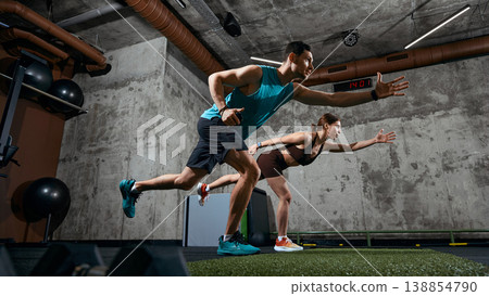 Man and woman performing functional training movement with forward reach in gym. Man and woman performing functional training movement with forward reach in gym. 138854790