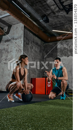 Personal trainer consulting woman during rest between exercises in functional training gym Personal trainer consulting woman during rest between exercises in functional training gym 138854870