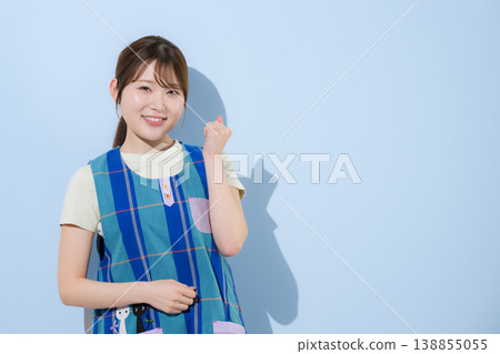 一張照片,照片中一位年輕的女教師擺出勝利的姿勢,她可能從事幼教工作、家事服務或提供幼教支持服務(例如發展支持和治療教育)。 一張照片,照片中一位年輕的女教師擺出勝利的姿勢,她可能從事幼教工作、家事服務或提供幼教支持服務(例如發展支持和治療教育)。 138855055