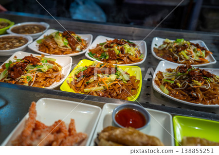 Local food and snacks including pork, Scallion Oil Noodles, intestines and seafood brochettes displayed in a popular market at night, Shanghai, China. Local food and snacks including pork, Scallion Oil Noodles, intestines and seafood brochettes displayed in a popular market at night, Shanghai, China. 138855251