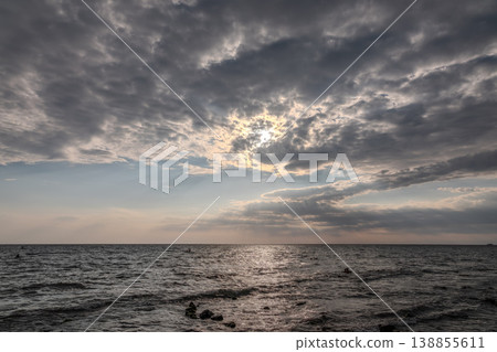 The sky is cloudy and the ocean is calm. The water is a deep blue color. The sky is cloudy and the ocean is calm. The water is a deep blue color. 138855611
