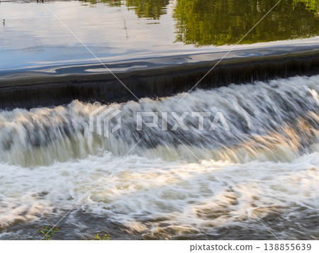 A small flat cascade in a calm river A small flat cascade in a calm river 138855639