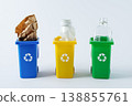 Sorting and recycling waste, three toy recycling bins for glass, paper, and plastic on white background. Color coded containers promoting eco friendly waste sorting and sustainable living. 138855761