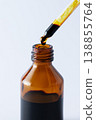 Bottle of iodine antiseptic with iodine drop falling from pipette on white background. Medical disinfectant concept, hygiene and infection prevention. 138855764