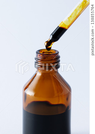 Bottle of iodine antiseptic with iodine drop falling from pipette on white background. Medical disinfectant concept, hygiene and infection prevention. Bottle of iodine antiseptic with iodine drop falling from pipette on white background. Medical disinfectant concept, hygiene and infection prevention. 138855764