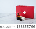 Iodine bottle, bandage, and first aid kit on table. Medical supplies for wound care, hygiene, and emergency treatment concept. 138855766