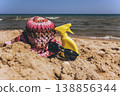 Sunscreen spray bottle with sunglasses and hat on sandy beach near sea Summer vacation concept with sun protection and copy space 138856344