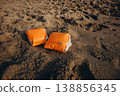 Inflatable armbands on sandy beach Child water safety concept swimming protection and learning basics of safe behavior near sea 138856345