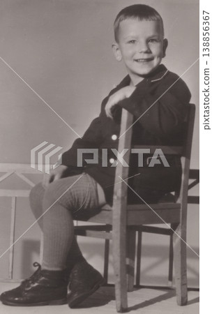 Vintage boy smiling seated on chair studio portrait 1960s Vintage boy smiling seated on chair studio portrait 1960s 138856367