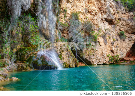 Serene Waterfall Cascading Into a Turquoise Pool Amid Rocky Cliffs in a Tranquil Nature Setting Serene Waterfall Cascading Into a Turquoise Pool Amid Rocky Cliffs in a Tranquil Nature Setting 138856506